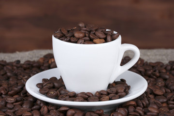 Composition of the white cup with coffee beans close-up