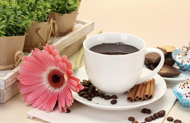 cup of coffee and gerbera  beans, cinnamon sticks