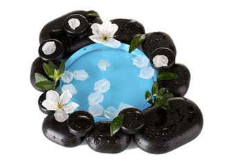 Composition of spa stones, blue water, petals and leaves