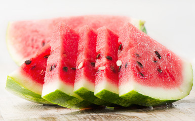 slices of  watermelon on wooden table