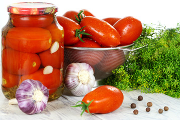 Canned tomatoes in the pot, fresh tomatoes and spices on a woode