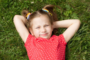 Girl with pigtails lying on grass
