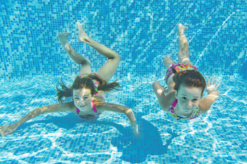 Happy smiling underwater children in swimming pool, kids sport