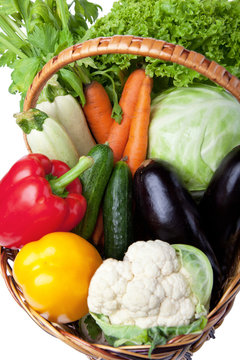 Fresh vegetables in a basket on white.