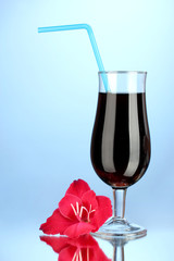 glass with cocktail and gladiolus bud