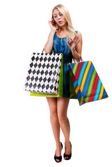 Young woman with shopping bags and mobile phone on a white backg