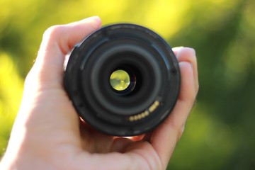 human hand holding a plain photo lens