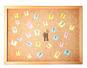Keys with many question marks on cork board