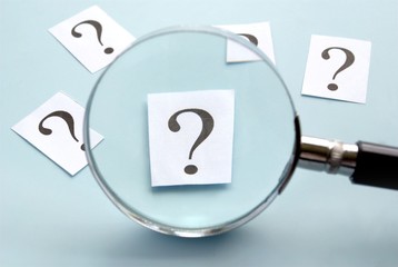 magnifying glass and a question mark on the paper
