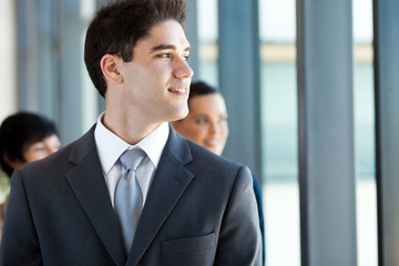young businessman looking outside office window