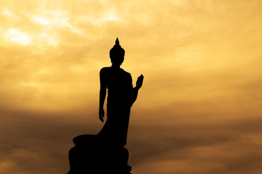 Buddha silhouette on sunset sky.