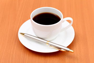 Black coffee in a cup and pen