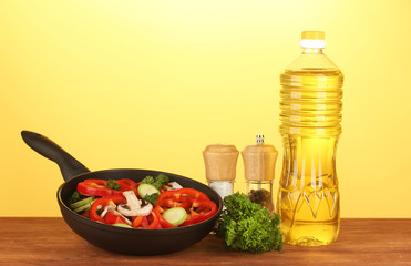 frying pan with vegetables on yellow background