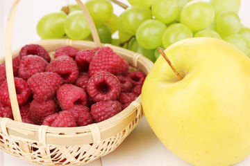 ripe sweet fruits and berries on wooden background