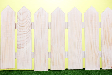 wooden fence and green grass on green background.