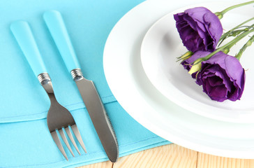 Tableware with flower on bright napkin close-up