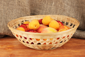 Ripe fruit in basket on canvas background close-up