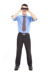 Fototapeta premium full length of businessman looks through binoculars and isolated