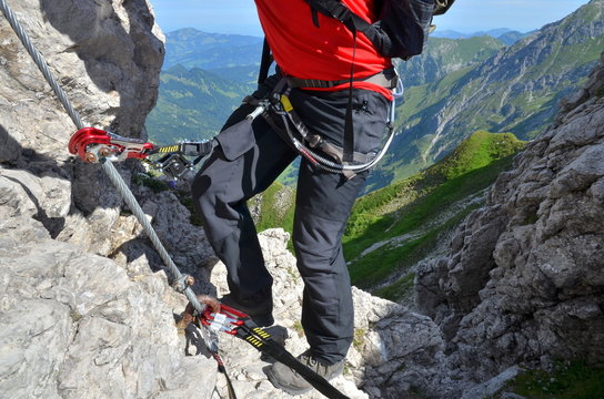 Bergsteiger mit Sicherung durch Karabiner und Klettergurt am Klettersteig  Stock-Foto | Adobe Stock