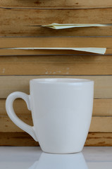 A cup of coffee in the front of book heap.