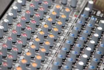 close up on knobs of sound mixing console in recording studio