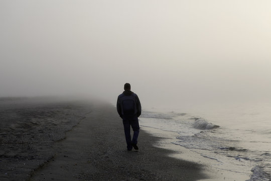 man walking alone on beach