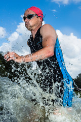 Fototapeta premium Triathlet rennt aus dem Wasser