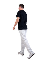 Back view of walking handsome man in t-shirt