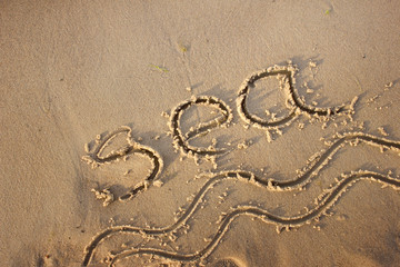 Fototapeta na wymiar Sea and waves drawn in the sand/Sea background with a sand