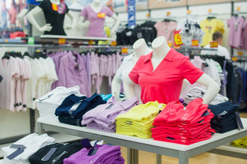 Color t-shirts and mannequins on table in mall