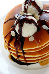 pancakes topped with ice cream, covered in chocolate sauce