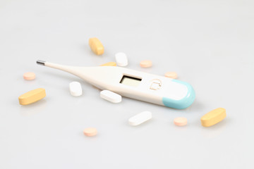 Thermometer and pills isolated on white