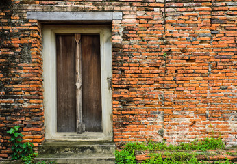 Thai wooden door on brick wall