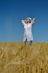 young woman in wheat field at summer