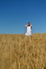 young woman in wheat field at summer