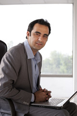 Portrait of a mature businessman with laptop