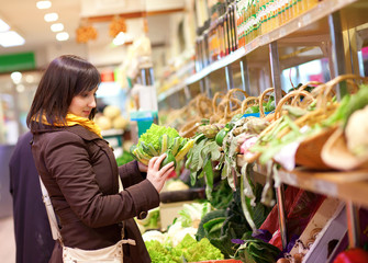 Beautiful young customer buying romanesco broccoli at market
