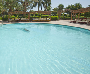 Man swimming in a tropical hotel pool