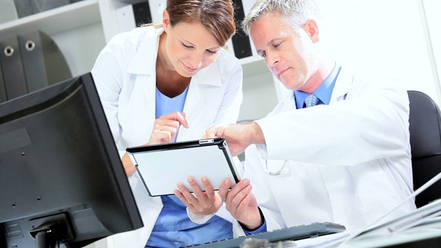 Doctors Checking Patient Information Wireless Tablet