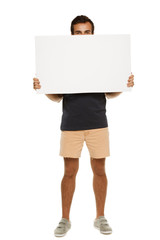 Full length man in summer clothing peeking from blank banner