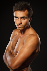 Fototapeta premium Young muscular male shirtless standing with folded hands