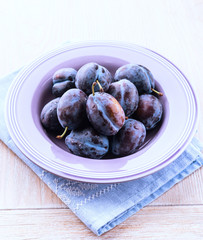 Fresh plums in a purple bowl