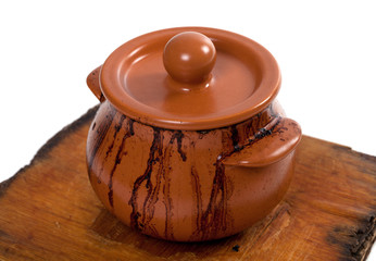 Dirty ceramic pot on old wooden kitchen board