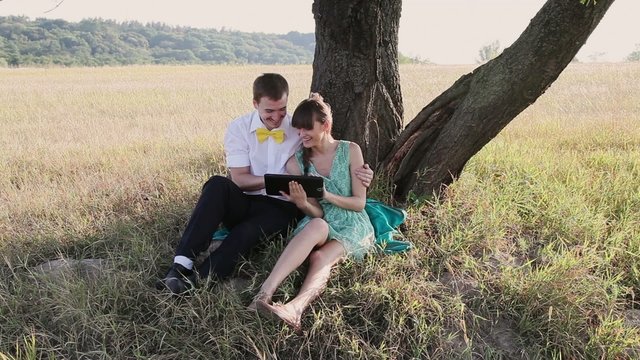 Young couple browsing in Internet with tablet and chating