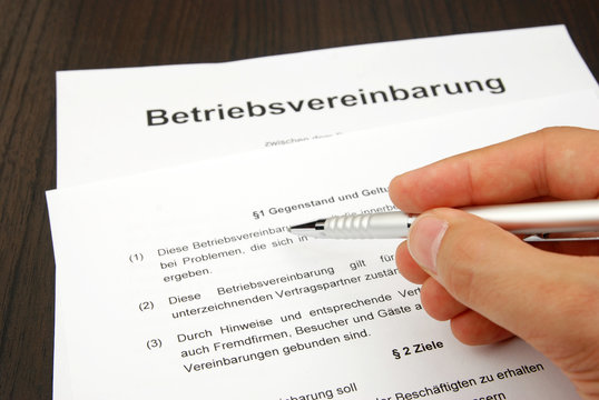 Betriebsvereinbarung mit Hand und Kugelschreiber