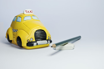 Taxi toy, pencil and rubber isolated on neutral background