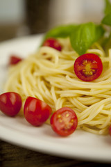 frische leckere Pasta mit Tomaten und Basilikum auf einem brett