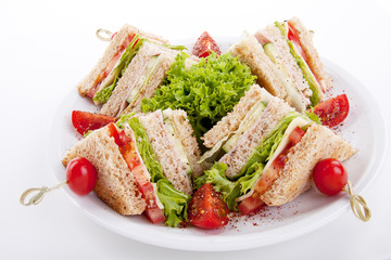 frisches Clubsandwich mit Schinken, Käse, Speck und Salat isoli