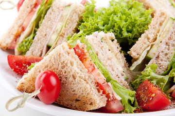 frisches Clubsandwich mit Schinken, Käse, Speck und Salat isoli