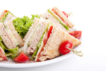 frisches Clubsandwich mit Schinken, Käse, Speck und Salat isoli